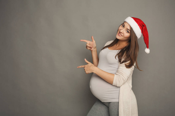 Jonge zwangere woman wijzend opzij portret. - Foto, afbeelding