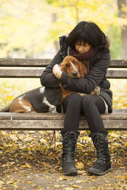 De vrouw met een hond in het park, een selectieve aandacht en een kleine scherptediepte, lens flare - Foto, afbeelding