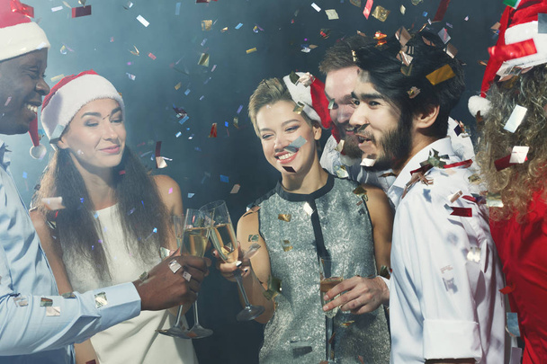 Amigos multirraciales tintineando gafas mientras celebran el Año Nuevo
 - Foto, Imagen