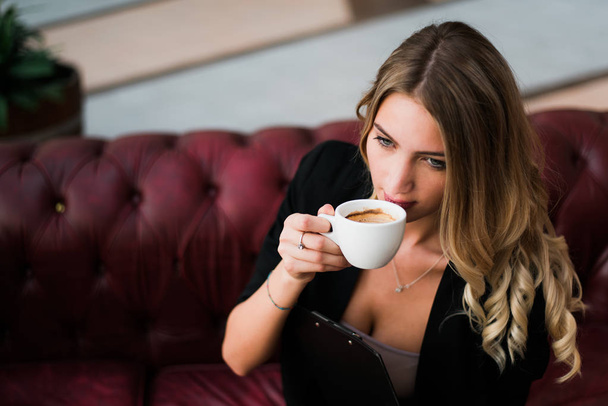Linda loira bem sucedida empresária trabalhando e bebendo café no escritório
. - Foto, Imagem