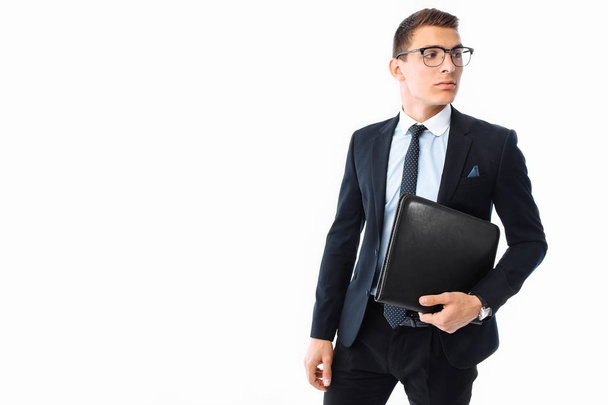 Business man in black suit and glasses, with folder in hand, smiling, isolated on white background - Foto, Imagem