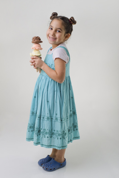 Little girl holding a cone with three ice cream - 写真・画像