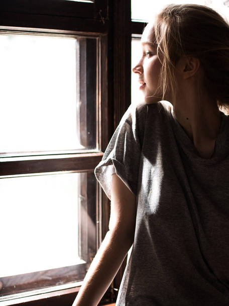 Young beautiful girl near the window. Light picture. - Foto, afbeelding