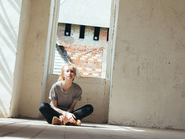 Beautiful young woman sits on the floor of the room. - Valokuva, kuva