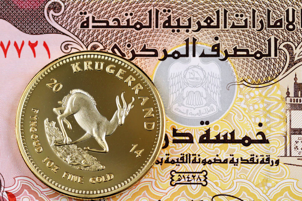 ein vereinigtes arabisches emirat fünf dirham note mit einer goldenen krugerrand-münze - Foto, Bild