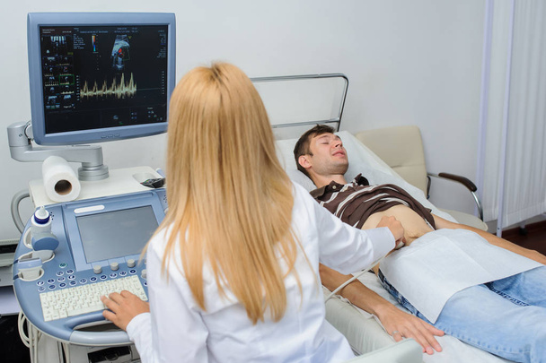 The lady  doctor  examination a man at abdomen with ultrasonography device - Foto, Imagem