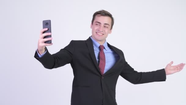 Young happy handsome businessman video calling with phone - Séquence, vidéo