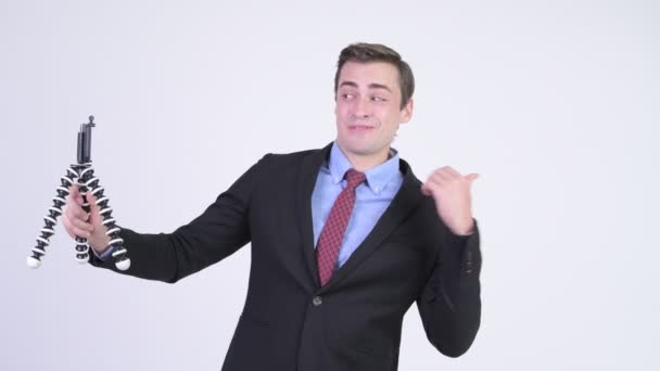Young happy handsome businessman vlogging with phone - Metraje, vídeo