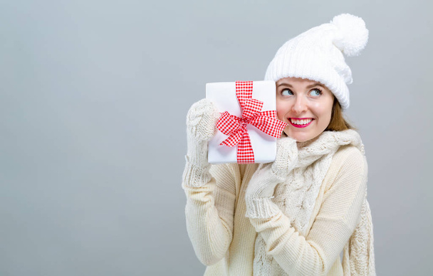 Young woman holding a gift box - Foto, imagen