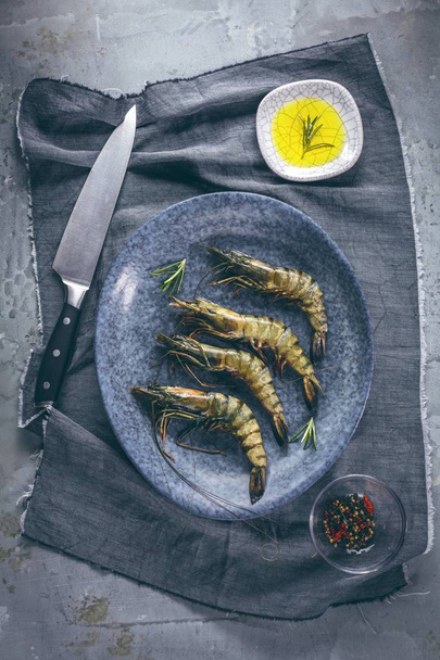 fresh shrimps or prawns raw on kitchen table board with ingredients - 写真・画像