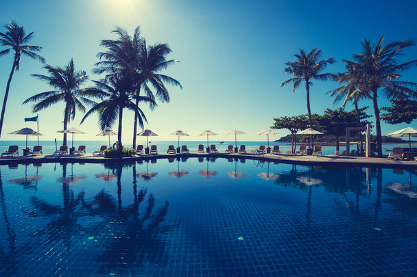 Bella spiaggia tropicale e mare con ombrellone e sedia intorno alla piscina in hotel resort per viaggi e vacanze - Foto, immagini