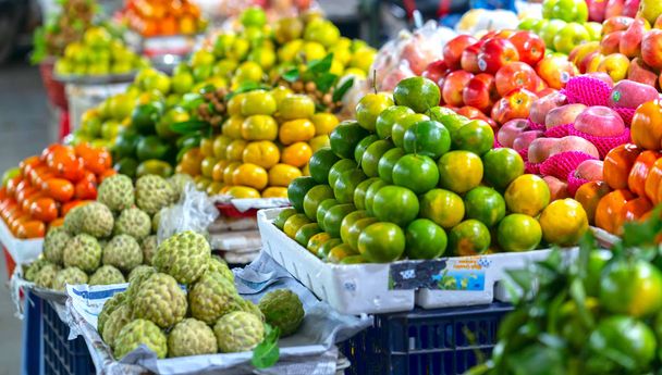Fruit op de markt met allerlei winkels zoals: mandarijnen. granaatappel, sinaasappel, appel, peer, druif, mango, dragon fruit, lychee... alle gerangschikt op planken look aantrekkelijke en opvallende. - Foto, afbeelding