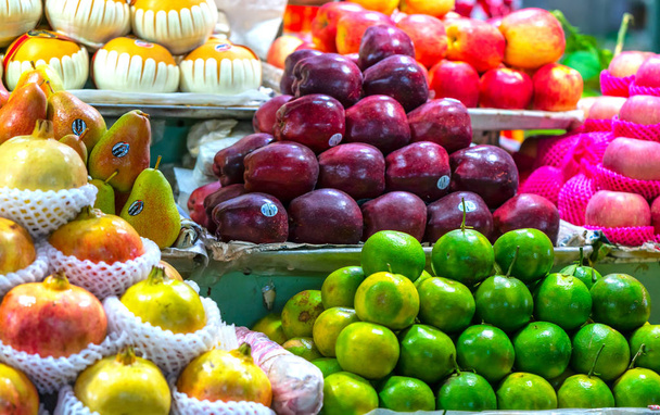 Lojas de frutas no mercado com todos os tipos, como: tangerinas. romã, laranja, maçã, pêra, uva, manga, fruta do dragão, lichia... tudo organizado em prateleiras olhar atraente e atraente
. - Foto, Imagem