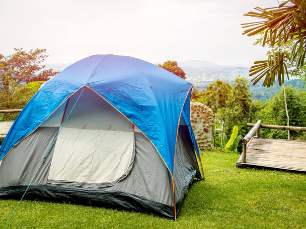 Camping barraca azul na grama verde com a vista para a montanha e céu azul
. - Foto, Imagem