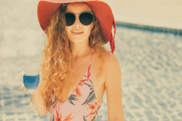glückliche junge Frau im Badeanzug, die Spaß am Schwimmbad im Luxus-Resort hat. Sommerreisekonzept. - Foto, Bild