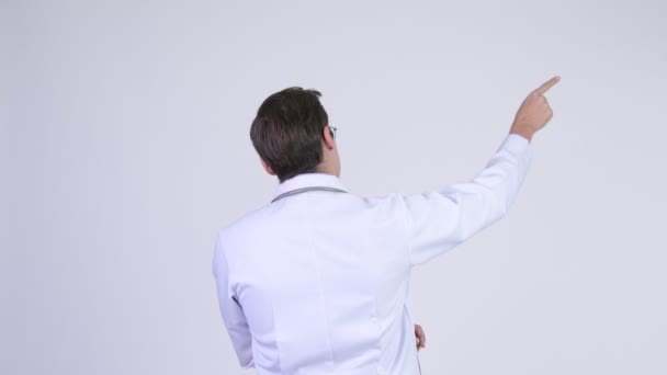 Rear view of young man doctor pointing up - Video, Çekim