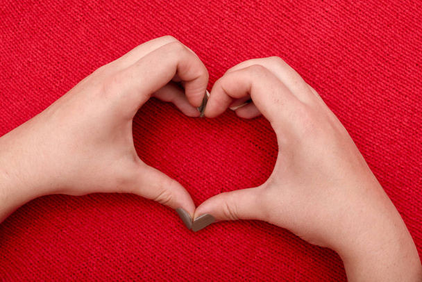 Krásné srdce žen ruce na červeném pozadí pletené - Fotografie, Obrázek