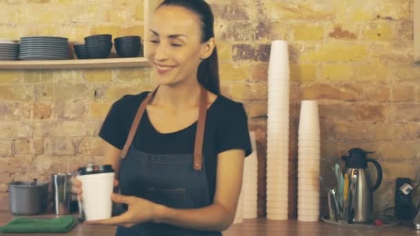 Camarera sonriente dando taza de café al cliente, que hace el pago NFC
. - Metraje, vídeo