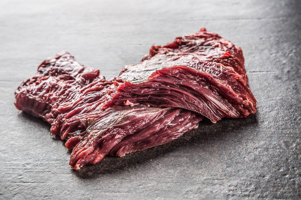 Portion of raw beef meat on dark butcher board. - Valokuva, kuva
