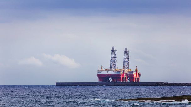 Две мачты нефтяной вышки в море возле береговой линии
. - Фото, изображение