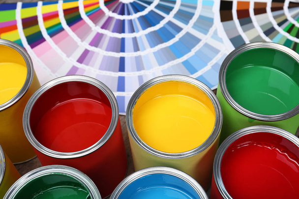Paint cans and color palette samples on table, closeup - Fotoğraf, Görsel