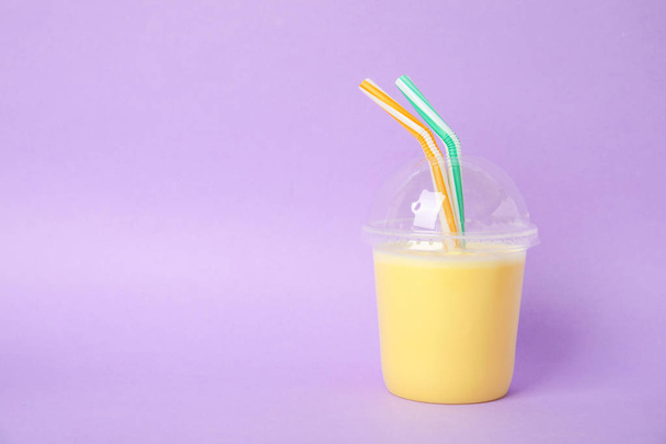 Plastic cup of tasty milk shake and space for text on color background - Fotografie, Obrázek