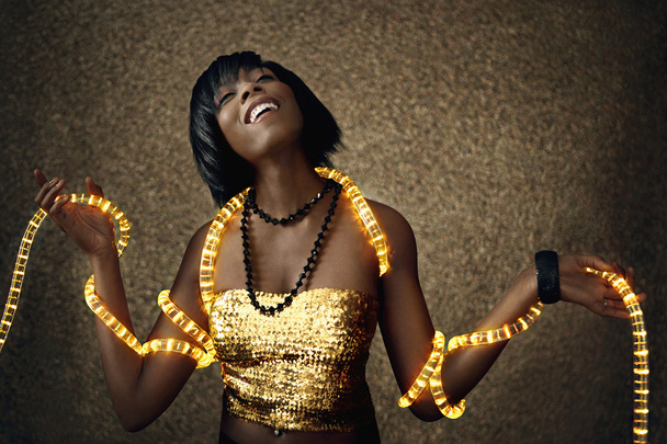 Mulher negra atraente dançando com luzes de Natal
 - Foto, Imagem