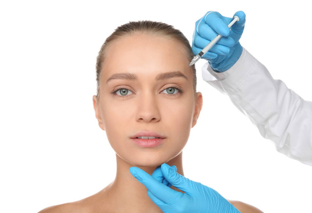 Young woman getting facial injection on white background. Cosmetic surgery concept - Foto, imagen