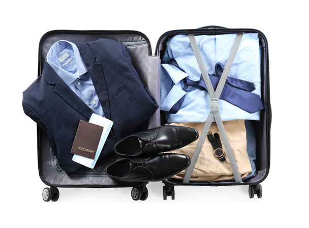 Packed suitcase with office wear and passport on white background, top view - Foto, Imagem
