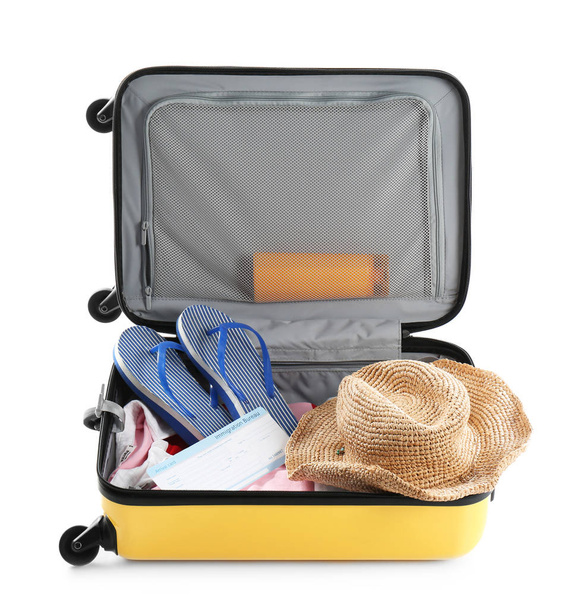gepackter Koffer mit Sommerkleidung und Accessoires auf weißem Hintergrund - Foto, Bild