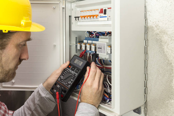 Elektriker am Arbeitsplatz misst den elektrischen Strom - Foto, Bild