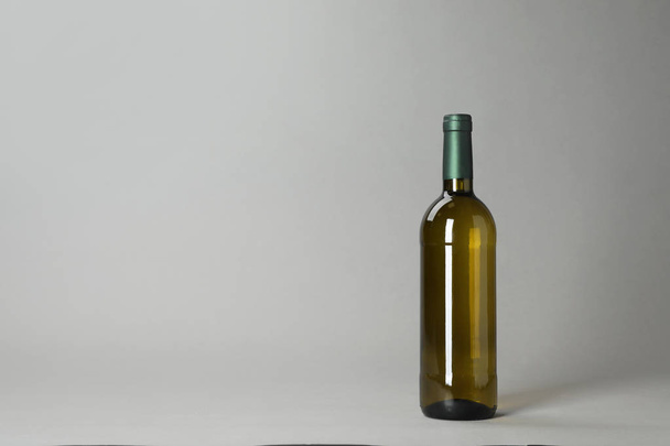 Bottle of wine on grey background. Space for text - Φωτογραφία, εικόνα