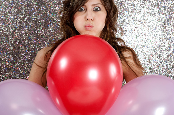 Portrait of an attractive young woman against a silver glitter background - Photo, Image