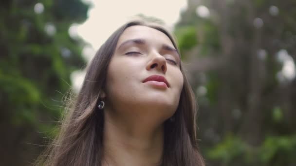Woman in closed eyes low angle shot, beautiful brunette feels nature oneness - Imágenes, Vídeo