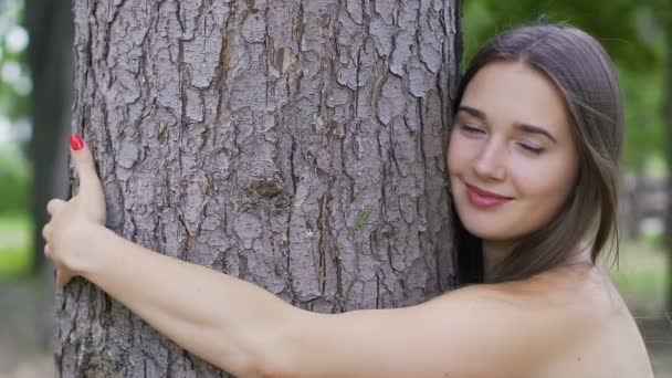 Mulher sorridente abraça uma árvore sorrindo, alegria de vida, amor natureza, proteção ambiental
 - Filmagem, Vídeo