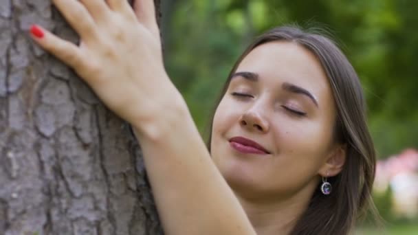 Young beautiful woman caresses tree, love of nature, feeling peace and unity - Filmagem, Vídeo