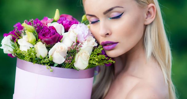 Spring woman enjoing flowers gift from lovely man. Spring look and makeup at beauty day. Womans day and gift on celebration. Gift for woman and happy female concept. 8 march woman. Gift box. - Foto, imagen