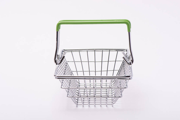 Cesta de enrejado de metal para comprar alimentos en un supermercado sobre un fondo blanco
 - Foto, Imagen