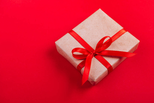 Present box with red bow on colorful background. Flat lay style. - Foto, Imagem