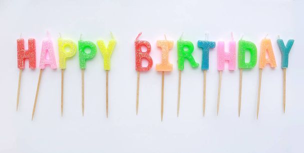 Multi-coloured Happy Birthday candles on white background. - Foto, Imagem