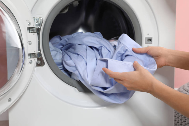 Woman taking laundry out of washing machine indoors, closeup - Фото, зображення