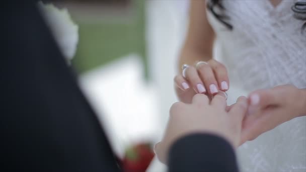 Bruid draagt een ring op bruidegoms vinger. De bruid en bruidegom uitwisseling van trouwringen. - Video