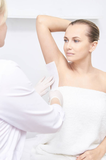 Unwanted hair wax epilation. Young Woman. cosmetology salon treatment procedure. Home waxing. - Foto, imagen