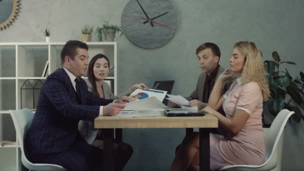 Business team discussing charts and graphs in office - Кадри, відео
