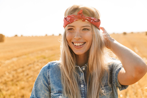 Весела молода блондинка в пов'язці на пшеничному полі
 - Фото, зображення