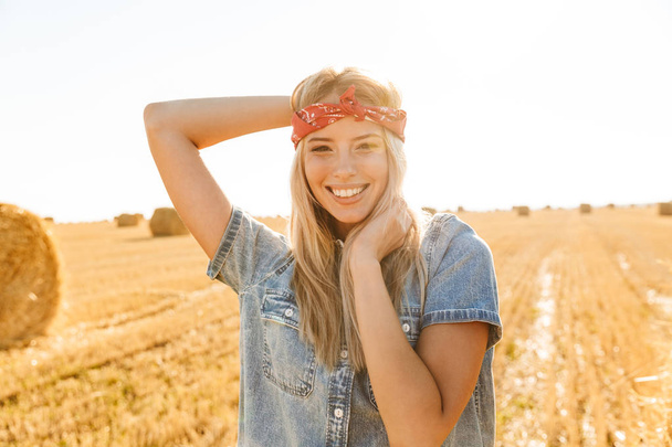 Joyful young blonde girl in headband at the wheat field - Фото, зображення