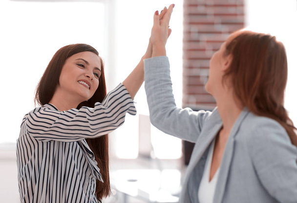 two young co-workers giving each other a high five - Photo, image