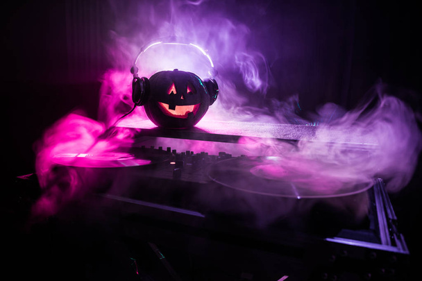 Dynia Halloween na stole dj słuchawki na ciemnym tle z miejsca kopii. Happy Halloween dekoracji festiwalu i koncepcja muzyki. Puste miejsce. Selektywny fokus - Zdjęcie, obraz