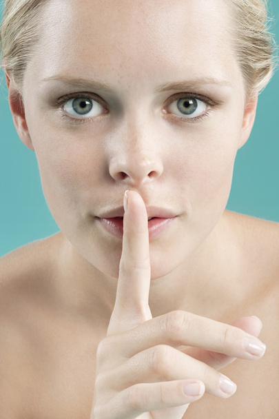 Porträt einer jungen Frau mit dem Finger vor dem Mund - Foto, Bild