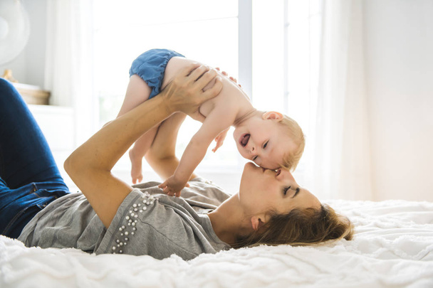 Mother and baby girl on bed - Photo, Image